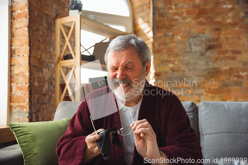 Image of Mature senior older man during quarantine, realizing how important stay at home during virus outbreak, suffers of glaucoma, eye deseases