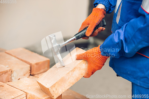 Image of Close up of hands of repairman, professional builder working outdoors, repairing