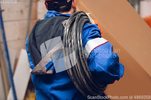 Image of Close up of hands of repairman, professional builder working outdoors, repairing