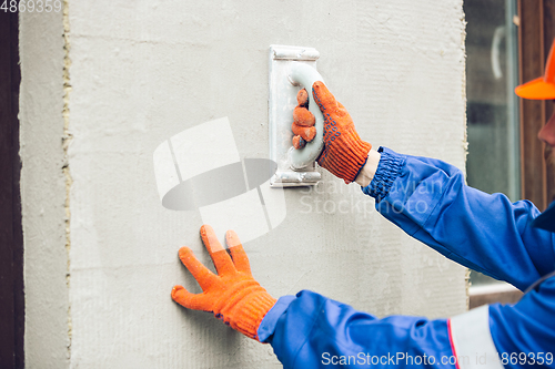 Image of Close up of hands of repairman, professional builder working outdoors, repairing