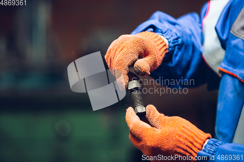 Image of Close up of hands of repairman, professional builder working outdoors, repairing