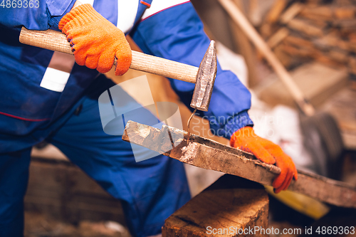 Image of Close up of hands of repairman, professional builder working outdoors, repairing