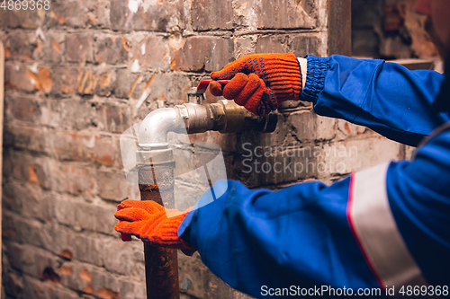 Image of Close up of hands of repairman, professional builder working outdoors, repairing