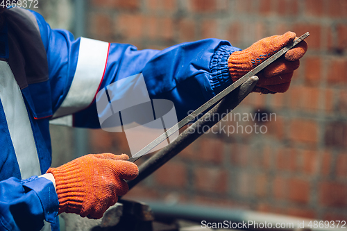 Image of Close up of hands of repairman, professional builder working outdoors, repairing