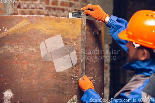 Image of Close up of hands of repairman, professional builder working outdoors, repairing