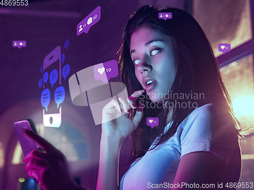 Image of Woman using interface modern technology and digital layer effect for social media displaying, looks attented