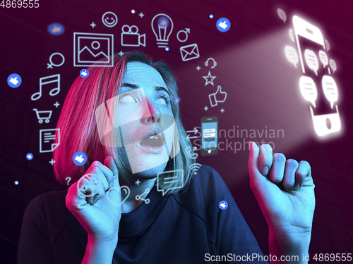 Image of Woman using interface modern technology and digital layer effect for social media displaying, looks shocked, scared