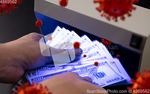 Image of Male hands checking of banknotes in the detector, 3D models of coronavirus spreding around