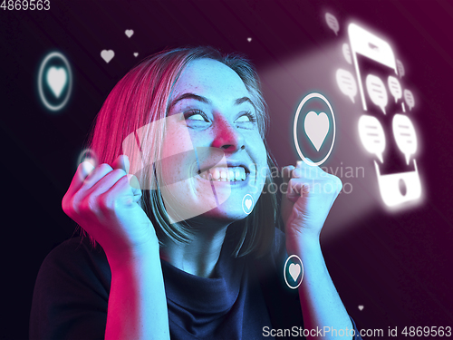 Image of Woman using interface modern technology and digital layer effect for social media displaying, looks happy getting likes