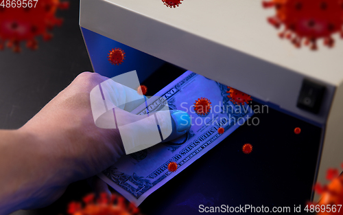 Image of Male hands checking of banknotes in the detector, 3D models of coronavirus spreding around