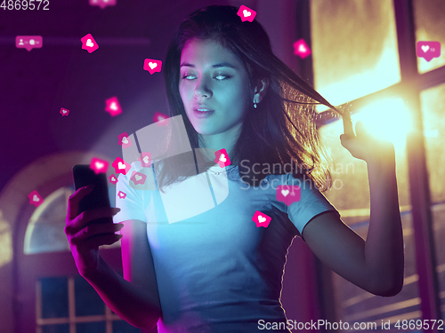 Image of Woman using interface modern technology and digital layer effect for social media displaying, looks attented