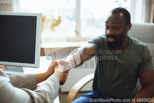 Image of Young man sitting in office during the job interview with female employee, boss or HR-manager, talking, thinking, looks confident