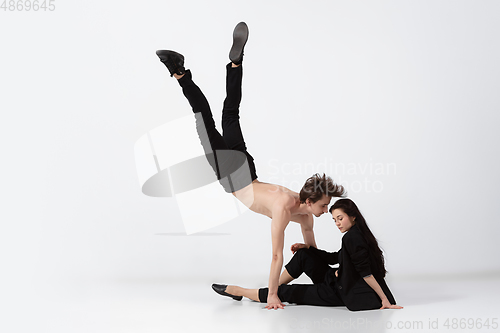 Image of Young and graceful ballet dancers in minimal black style isolated on white studio background