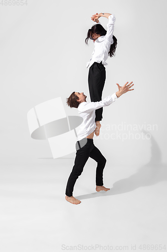 Image of Young and graceful ballet dancers in minimal black style isolated on white studio background