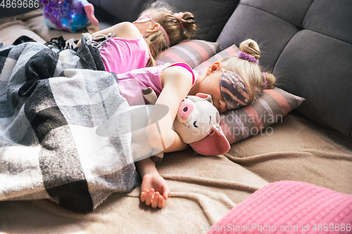 Image of Quiet little girls sleeping in a bedroom in cute pajamas, home style and comfort