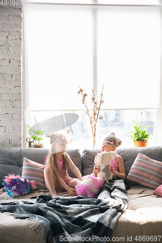 Image of Quiet little girls waking up in a bedroom in cute pajamas, home style and comfort