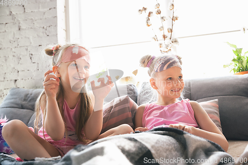 Image of Quiet little girls waking up in a bedroom in cute pajamas, home style and comfort