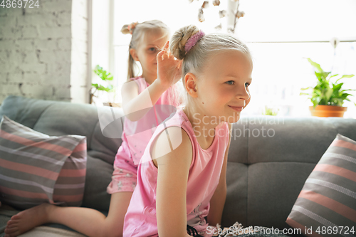 Image of Quiet little girls playing in a bedroom in cute pajamas, home style and comfort, making a hairstyle