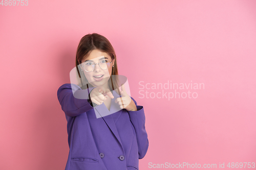 Image of Caucasian young woman\'s portrait on pink studio background, emotional and expressive