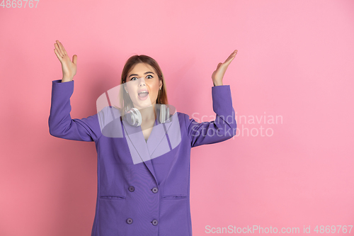 Image of Caucasian young woman\'s portrait on pink studio background, emotional and expressive