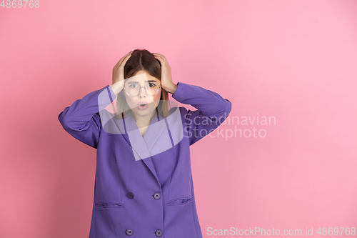 Image of Caucasian young woman\'s portrait on pink studio background, emotional and expressive