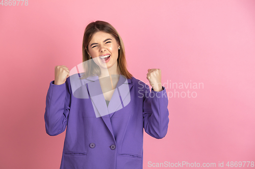 Image of Caucasian young woman\'s portrait on pink studio background, emotional and expressive