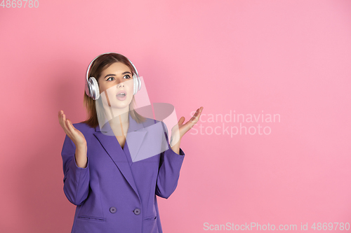 Image of Caucasian young woman\'s portrait on pink studio background, emotional and expressive