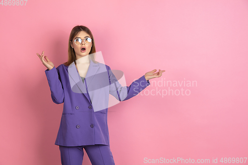 Image of Caucasian young woman\'s portrait on pink studio background, emotional and expressive