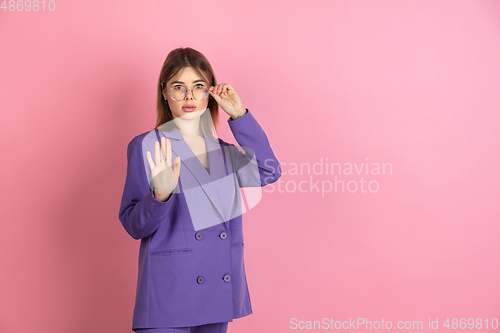 Image of Caucasian young woman\'s portrait on pink studio background, emotional and expressive