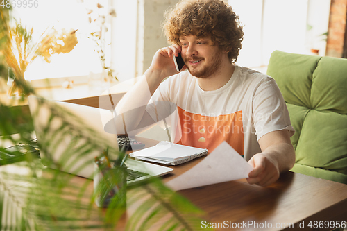 Image of Caucasian upset and despair man watching financial and economical reports with income graphs going down during coronavirus quarantine. Problems, empty wallet