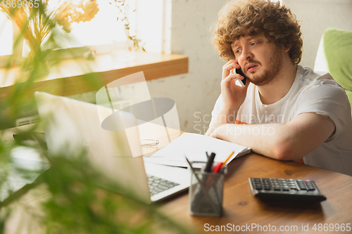 Image of Caucasian upset and despair man watching financial and economical reports with income graphs going down during coronavirus quarantine. Problems, empty wallet