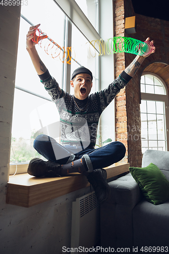 Image of Portrait of millenial boy using retro toys, meeting things from the past and having fun, exploring rainbow spring toy