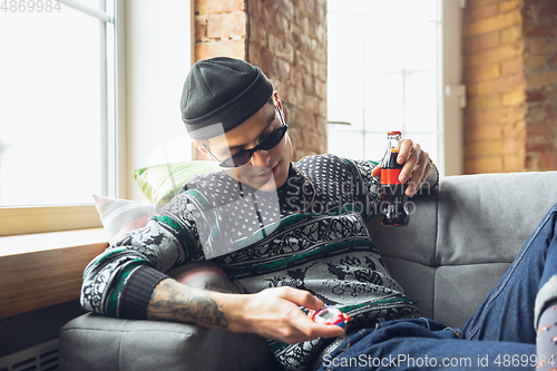 Image of Portrait of millenial boy using retro toys, meeting things from the past and having fun, exploring tamagotchi, virtual pet game