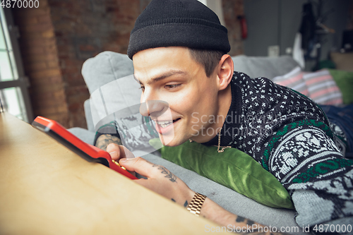 Image of Portrait of millenial boy using retro toys, meeting things from the past and having fun, exploring tetris game