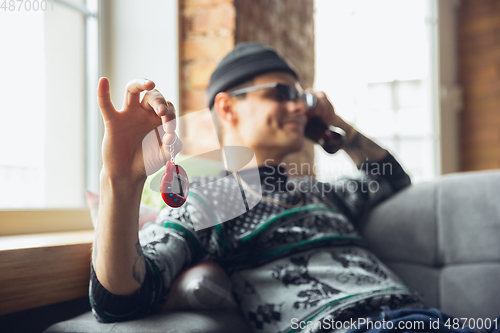 Image of Portrait of millenial boy using retro toys, meeting things from the past and having fun, exploring tamagotchi, virtual pet game