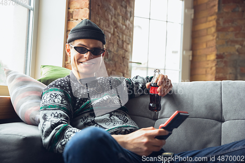 Image of Portrait of millenial boy using retro toys, meeting things from the past and having fun, exploring tetris game