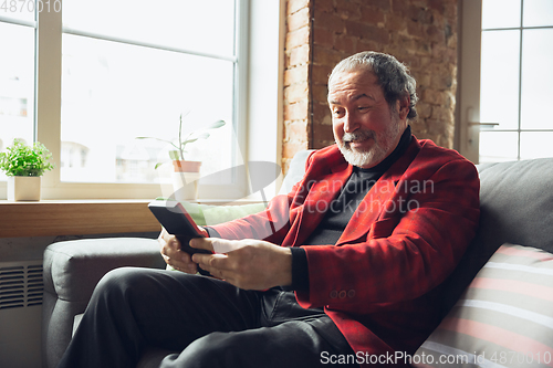 Image of Portrait of senior man with retro toys, meeting things from the past and having fun, exploring the lifestyle of the nineties, playing with tetris