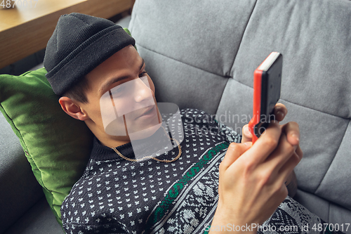 Image of Portrait of millenial boy using retro toys, meeting things from the past and having fun, exploring tetris game