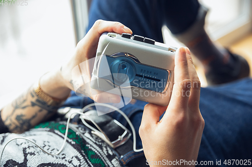 Image of Close up of millenial boy using retro toys, meeting things from the past and having fun, exploring music cassette player