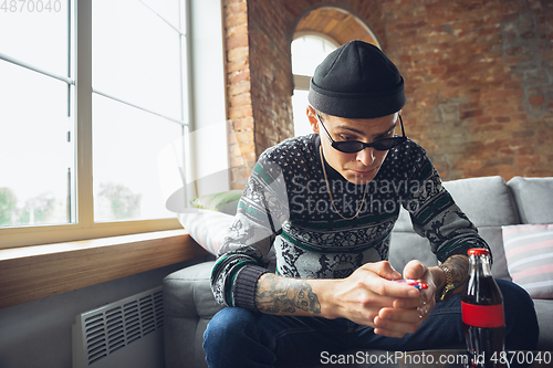 Image of Portrait of millenial boy using retro toys, meeting things from the past and having fun, exploring tamagotchi, virtual pet game