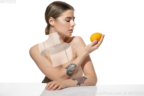 Image of Balanced. Beautiful young woman with orange over white background. Cosmetics and makeup, natural and eco treatment, skin care.