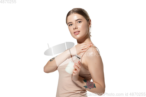 Image of Beautiful young woman massaging her skin with moisturizer over white background. Cosmetics and makeup, natural and eco treatment, skin care.