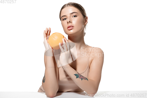 Image of Dreams. Beautiful young woman with orange over white background. Cosmetics and makeup, natural and eco treatment, skin care.