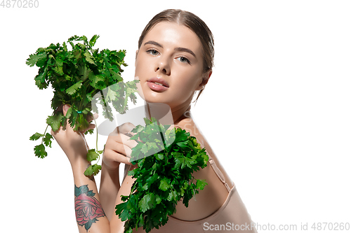 Image of Healthy. Beautiful young woman with green leaves on her face over white background. Cosmetics and makeup, natural and eco treatment, skin care