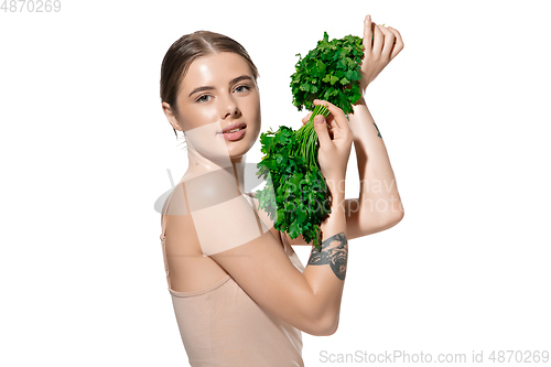 Image of Healthy. Beautiful young woman with green leaves on her face over white background. Cosmetics and makeup, natural and eco treatment, skin care