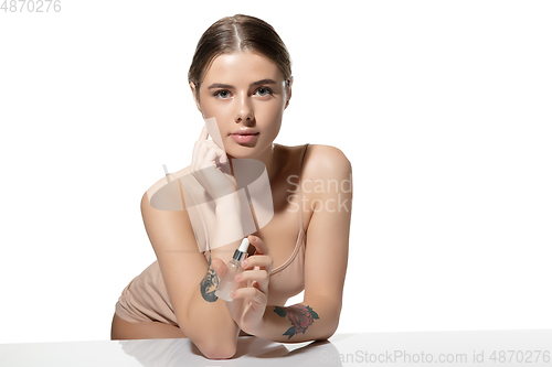 Image of Choice. Beautiful young woman with essential oil over white background. Cosmetics and makeup, natural and eco treatment, skin care.
