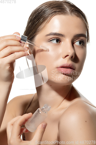 Image of Skin nutrition. Beautiful young woman with essential oil pouring over white background. Cosmetics and makeup, natural and eco treatment, skin care.