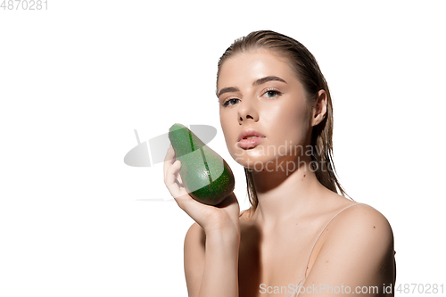 Image of Fashionable. Beautiful young woman with fresh avocado over white background. Cosmetics and makeup, natural and eco treatment, skin care