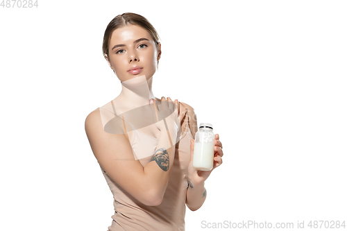 Image of Beautiful young woman massaging her skin with moisturizer over white background. Cosmetics and makeup, natural and eco treatment, skin care.
