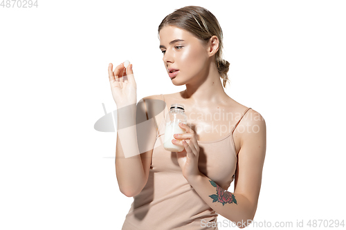 Image of Beautiful young woman massaging her skin with moisturizer over white background. Cosmetics and makeup, natural and eco treatment, skin care.